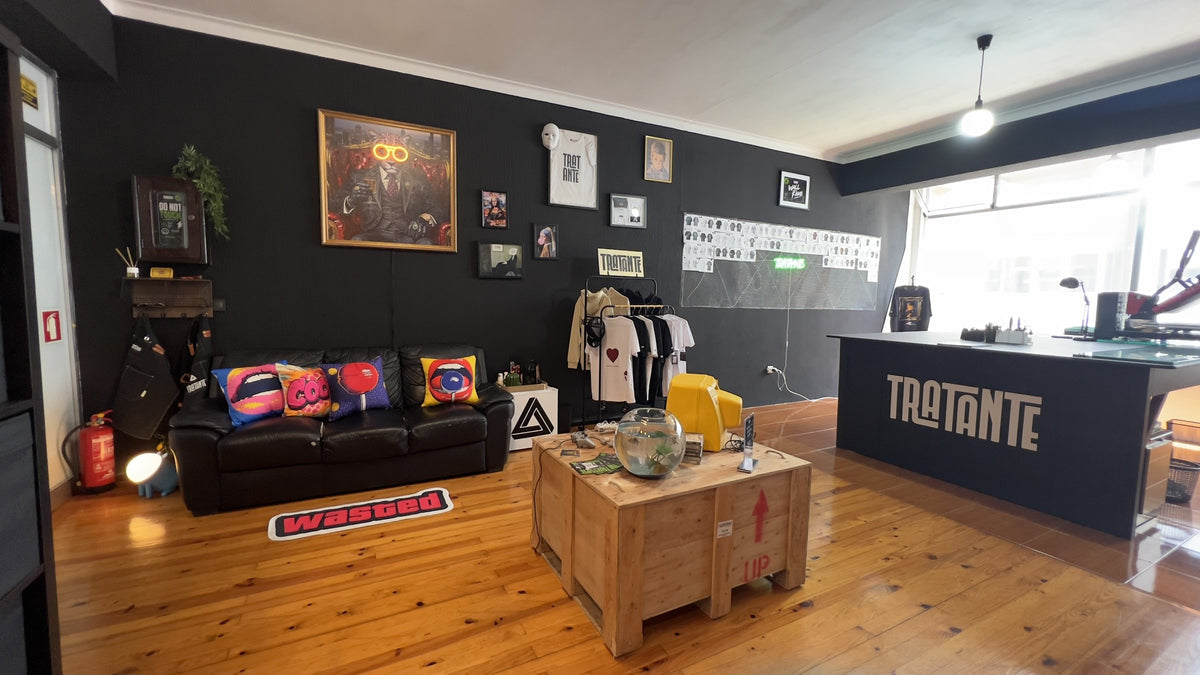 A Oficina TRATANTE hoje: sofá, arara de t-shirts, parede de quadros e balcão