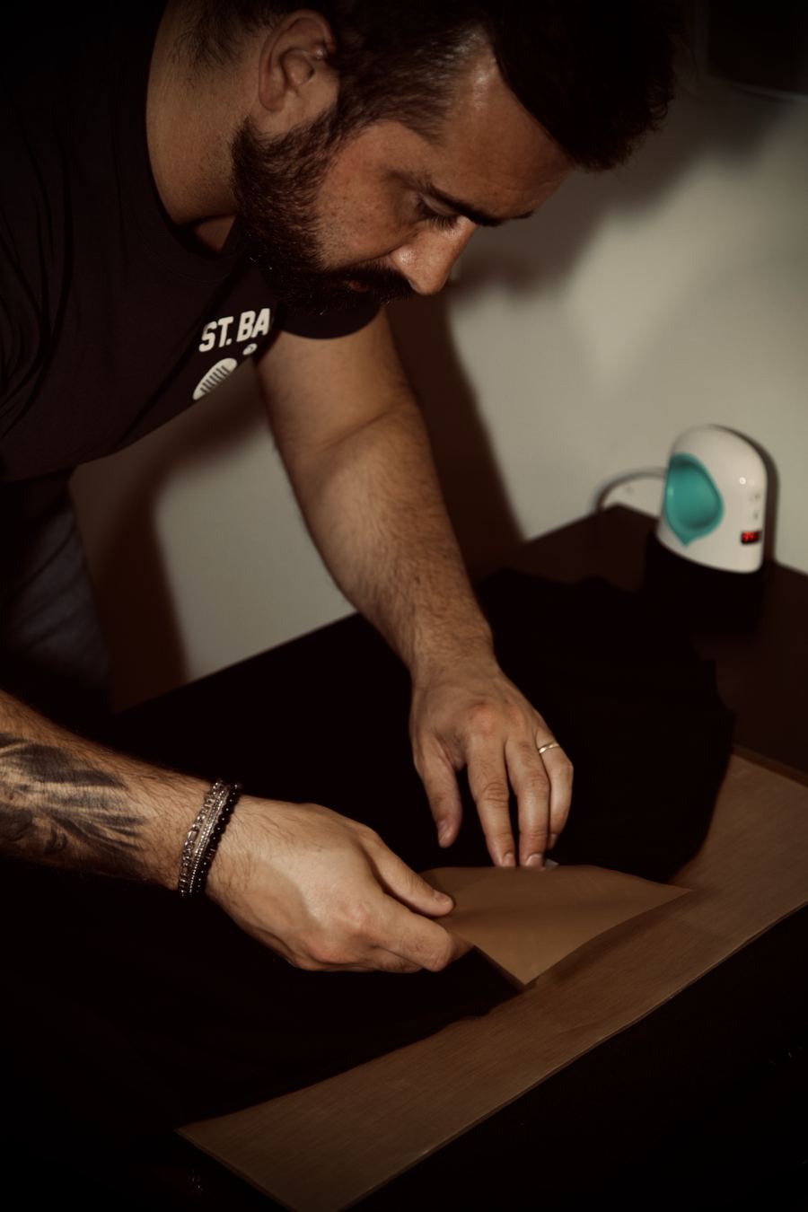 Mãos a retirar o papel de transferência de uma t-shirt