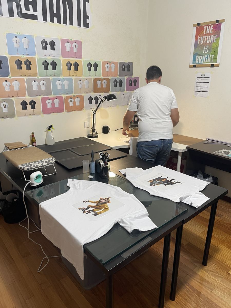 T-shirts brancas com desenhos em cima de uma mesa de vidro
